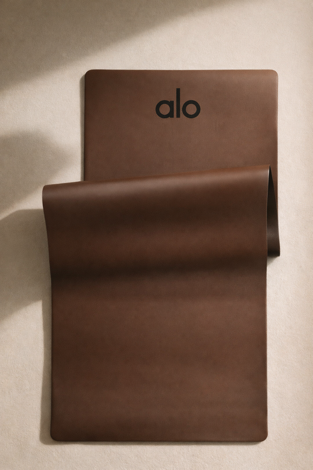 Unrolled espresso luxury ALO yoga mat showing smooth non-slip surface and premium texture
